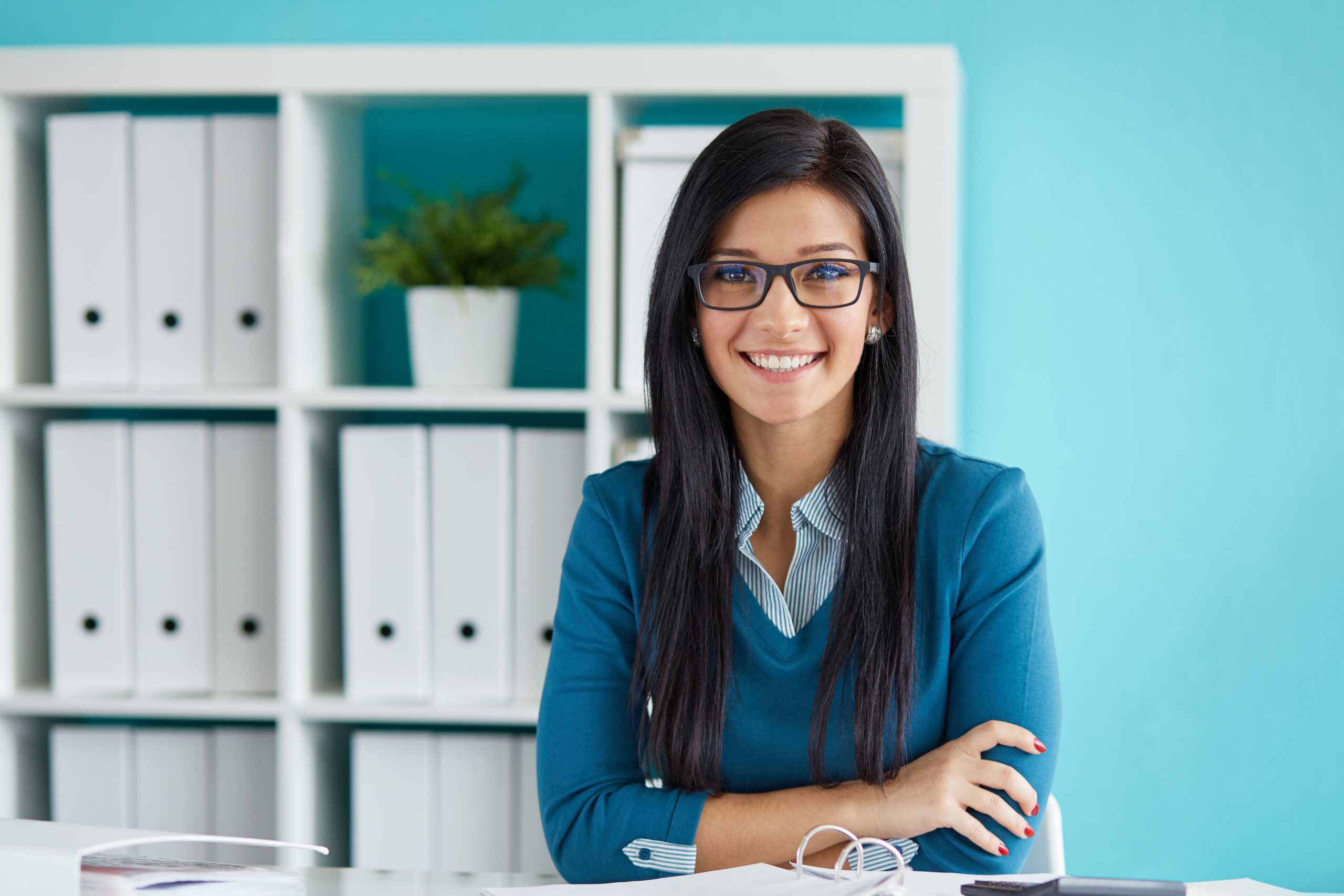 A woman sitting at her desk in front of some books